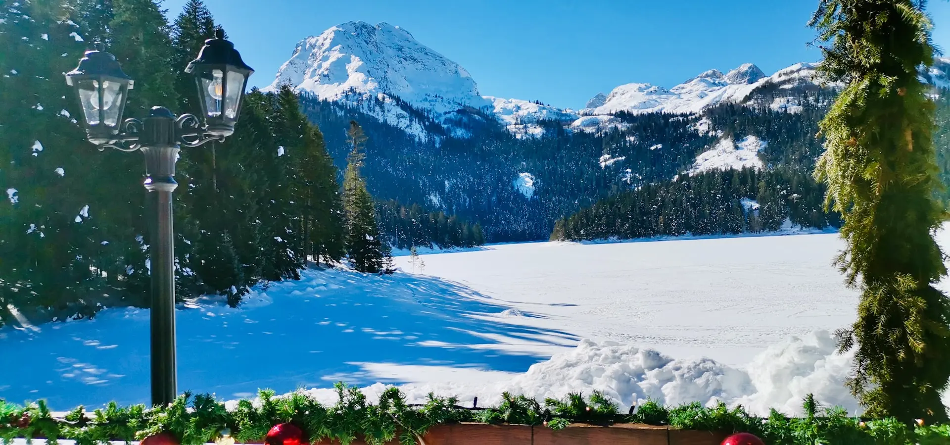 a view of a snow covered mountain and a park bench